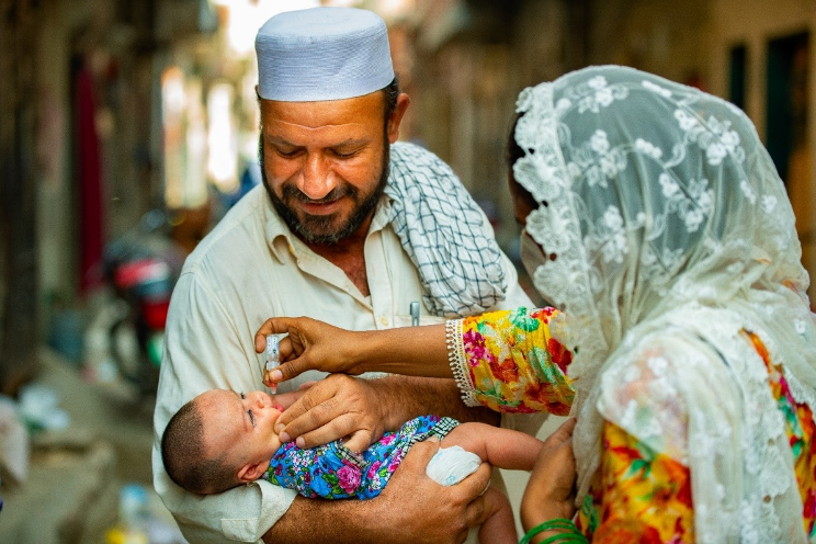 Polio staff Husna Bibi (24) is vaccinating a four-month old girl in UC-117, Maraghzar Colony, Lahore, Pakistan during case response in August to help end polio.