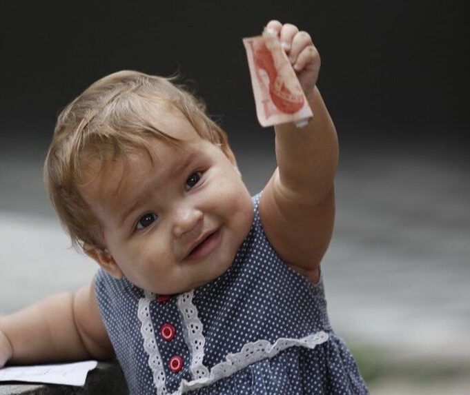 Child - European girl holding up money